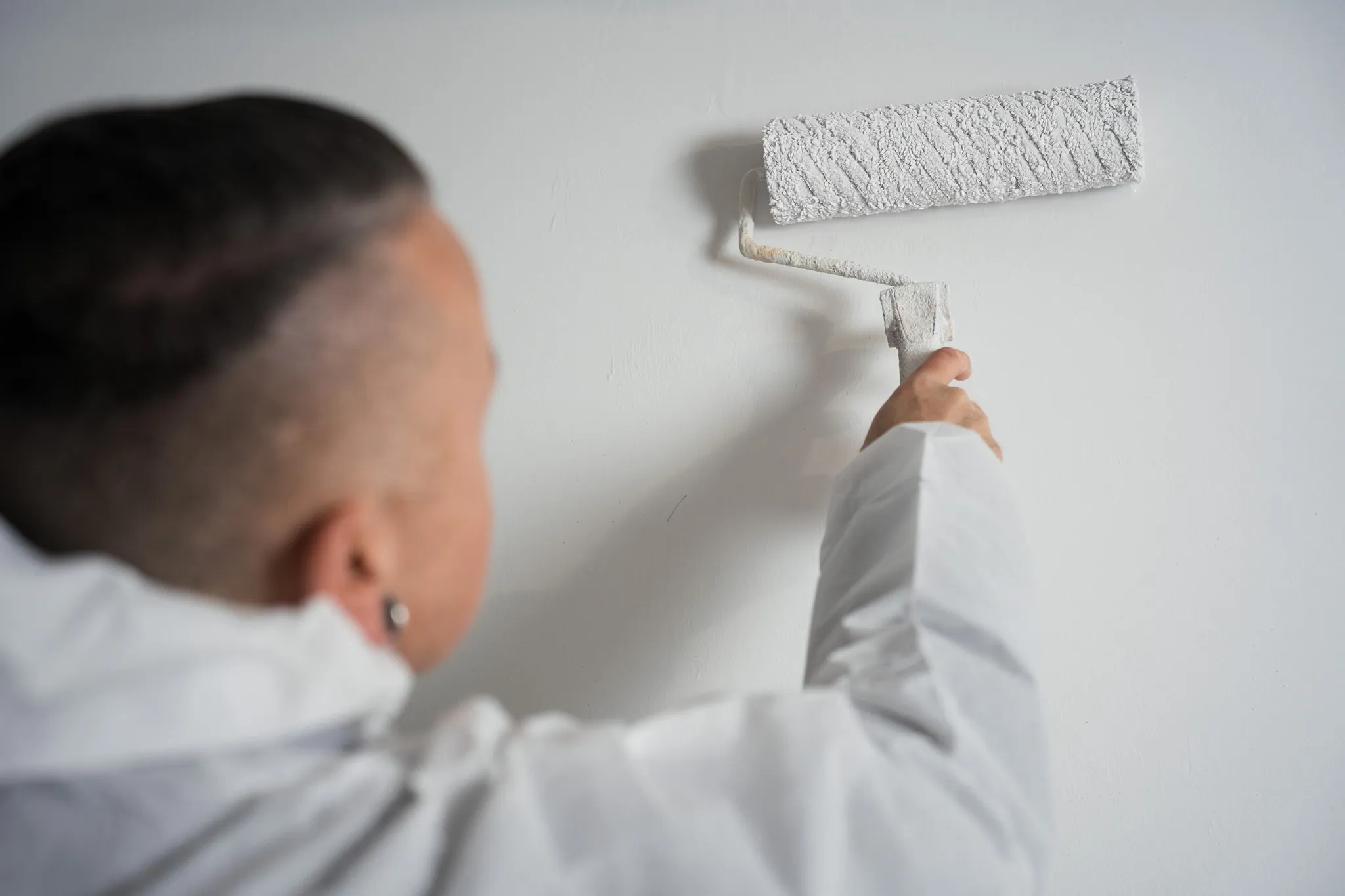 Wand wird nach der Sanierung mit der Farbrolle gestrichen