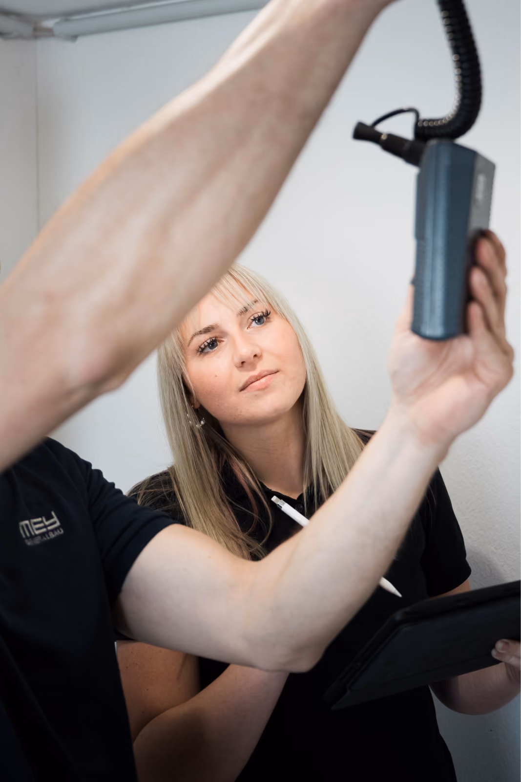 Mitarbeiterin misst die Feuchtigkeit an der Decke