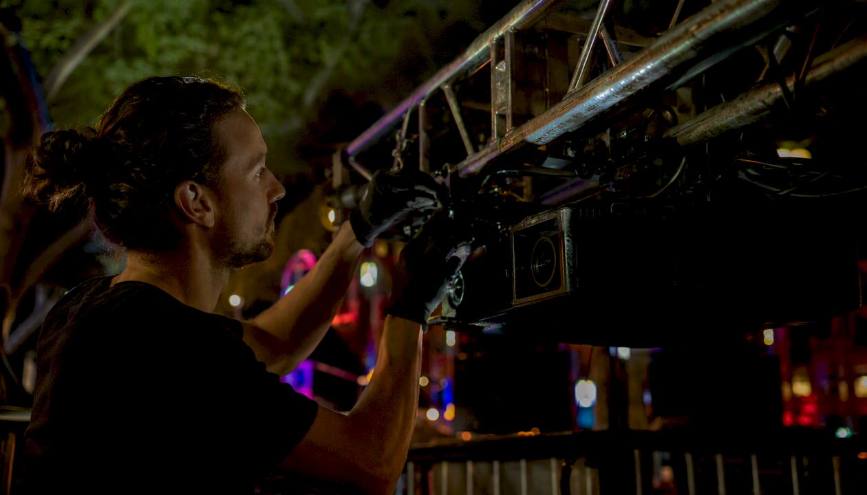 Technician rigging projection mapping equipment