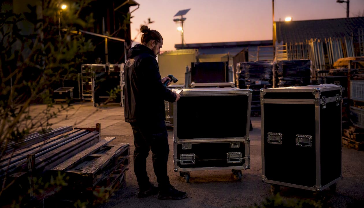 Technician scanning and photographing event asset crates