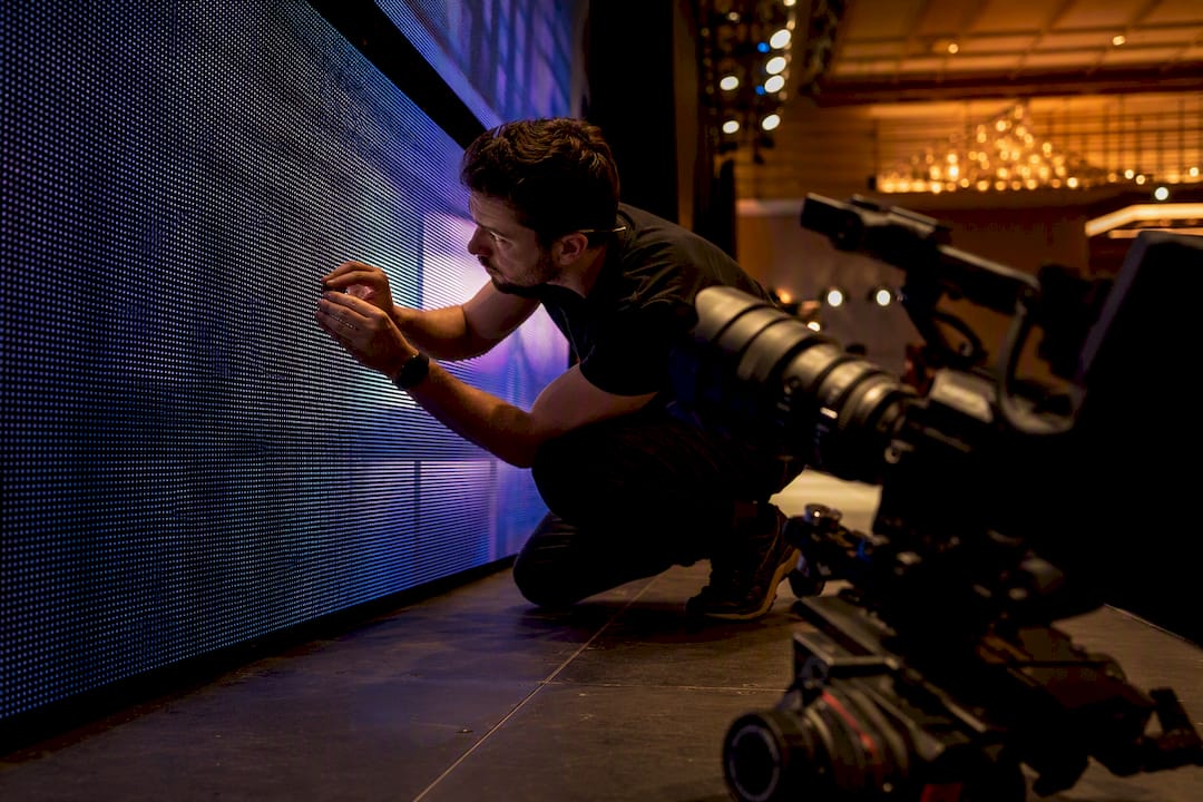 Camera lens focusing on LED screen during event setup