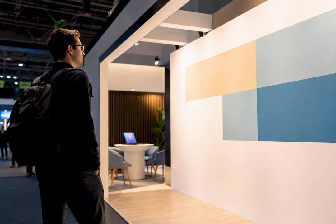 Visitor viewing illuminated exhibition booth wall