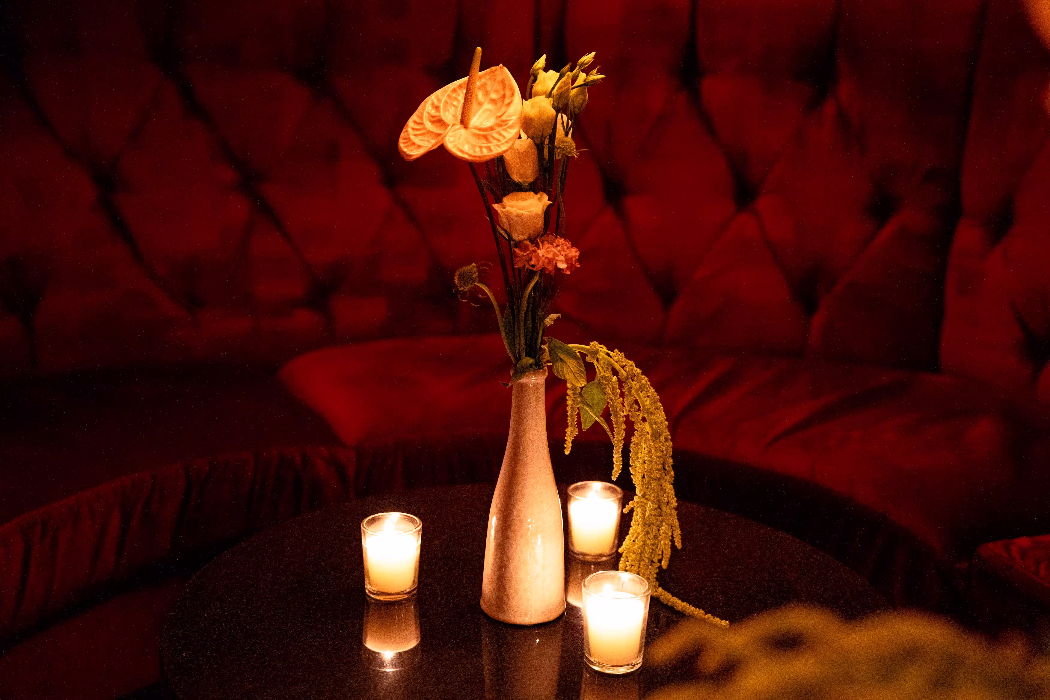 tiki inspired bar shelf featuring retro red radios, red tiki glasses, ray-ban signs, sunglasses, illuminated at dusk for a private event
