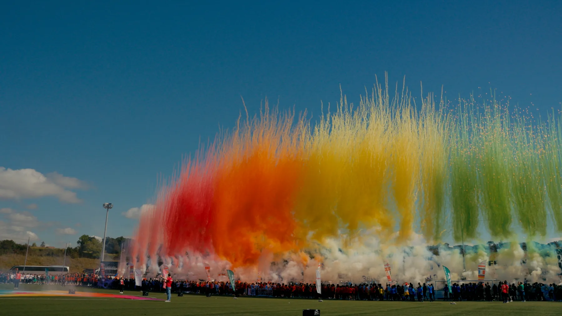 Regenbogen aus farbigem Rauch über dem Stadion bei KOMM MIT
