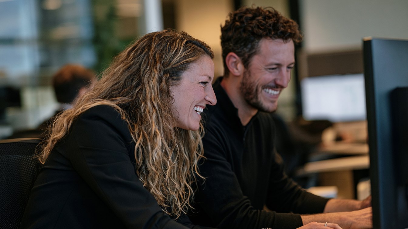 Two Union team members working alongside a leasing team at a monitor in an open office.