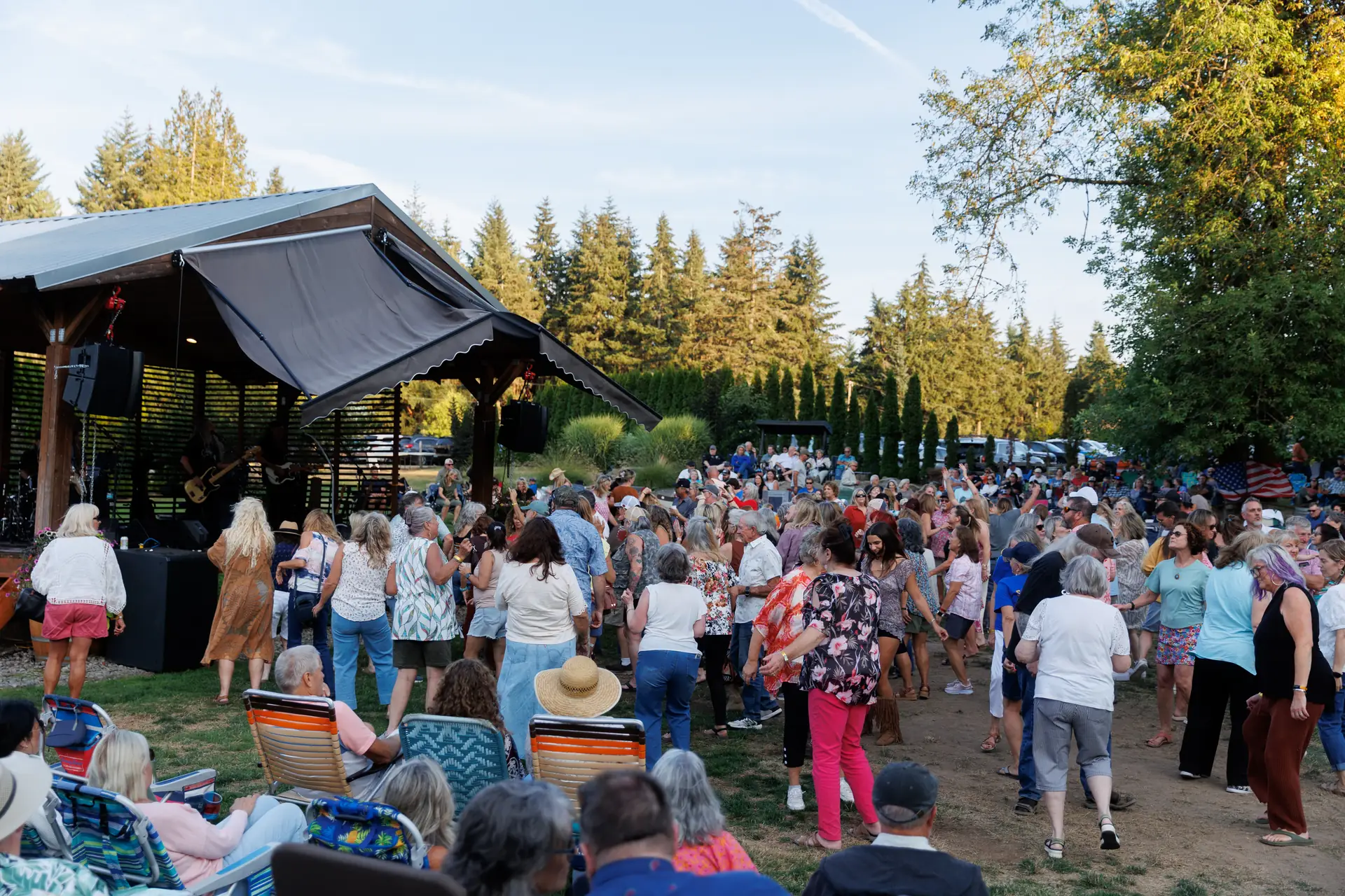 A crowd on the lawn watching a live band at a 14 Acres summer concert