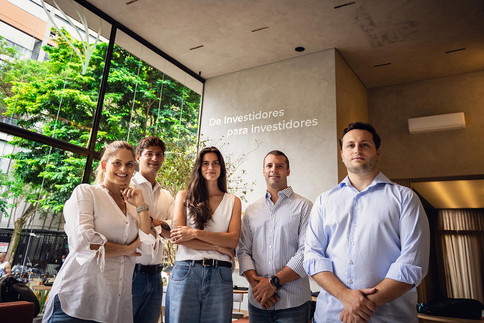 Sócios e executivos da Indepy reunidos em frente ao painel da marca