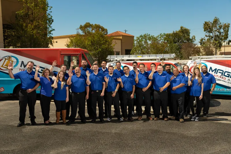 Members of the team at Magnolia standing outside together in from of Magnolia trucks.