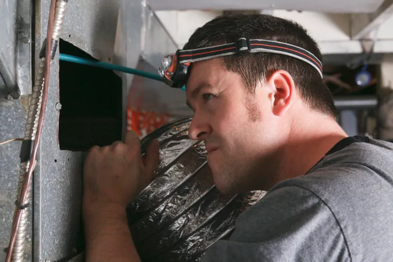 A tech getting into a duct.