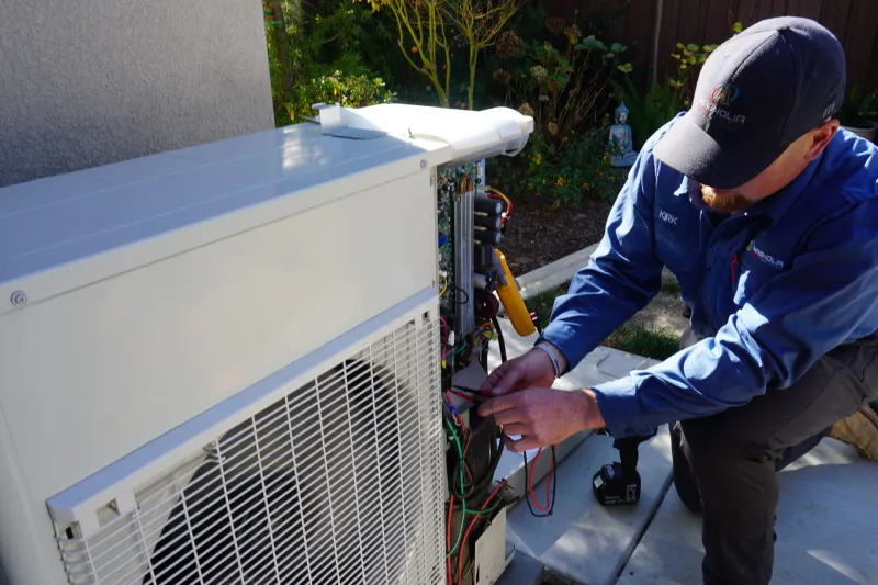 A tech working on a heat pump