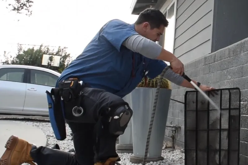 A tech cleaning an AC unit's filter