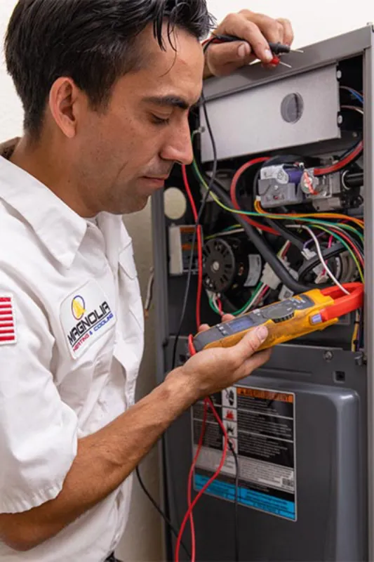 A tech checking a HVAC unit.