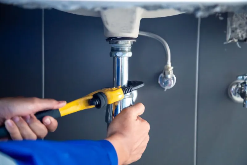 A tech working on a sink.