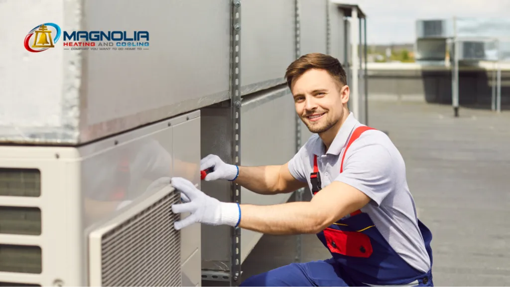 A smiling man working on an HVAC unit.