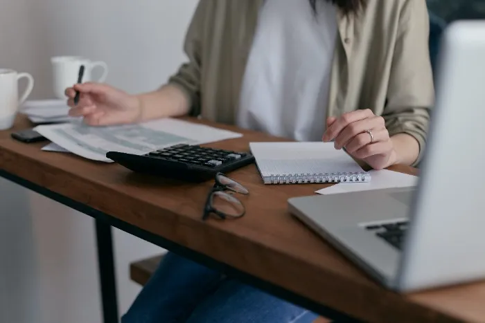 A woman looking over tax information at a desk.