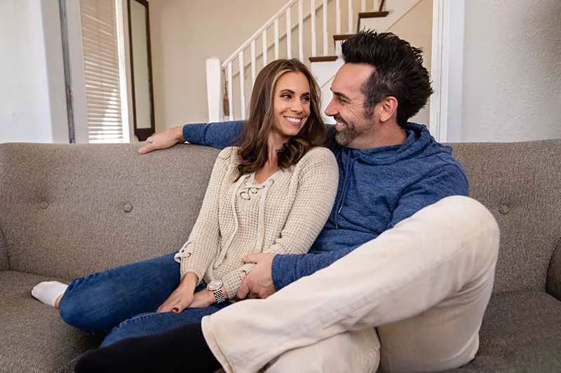A couple relaxing together on a couch.