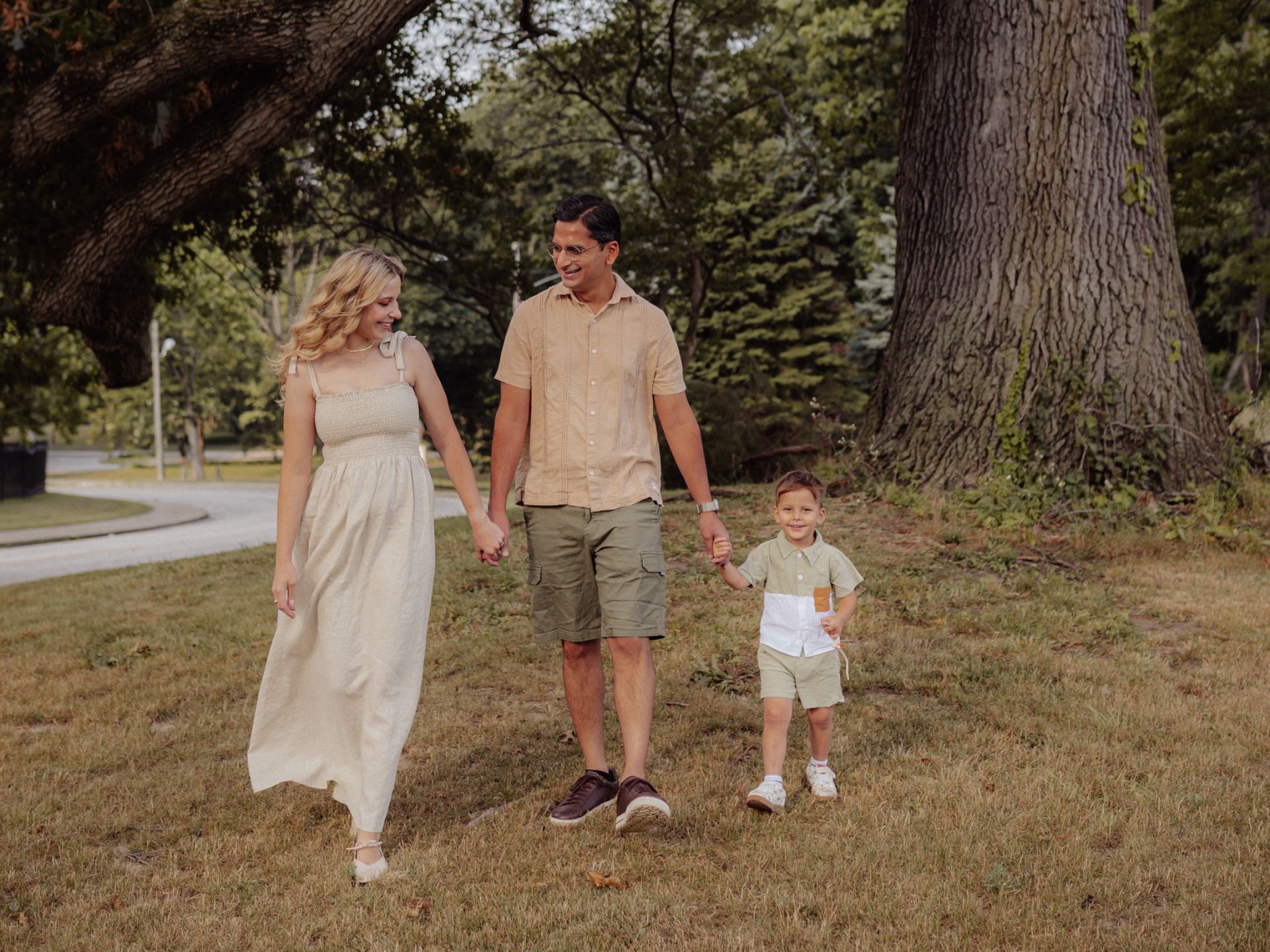 Family of three holding hands while walking through a park in Westfield Center, OH