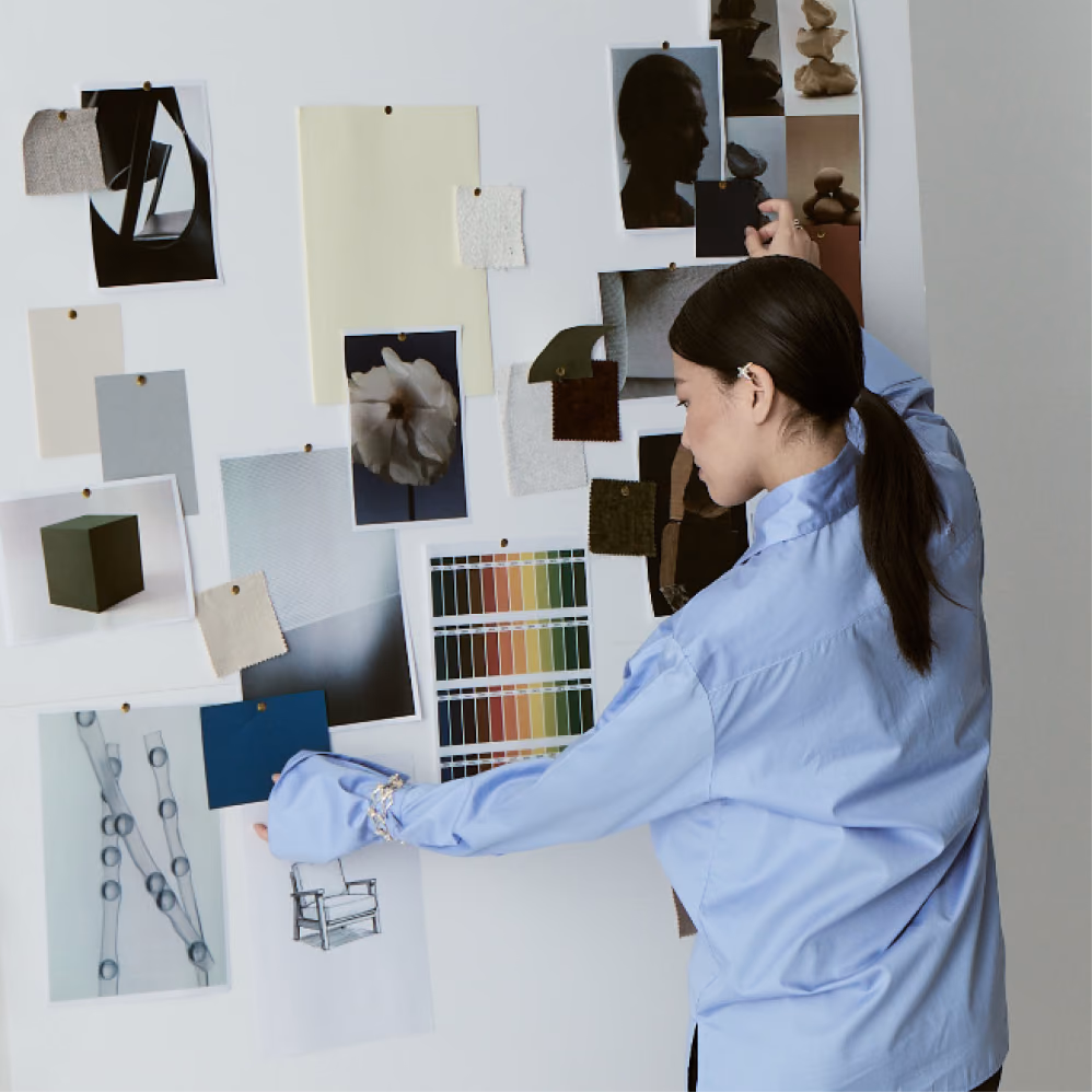 Creative director arranging photographs, fabric swatches and colour charts on a wall