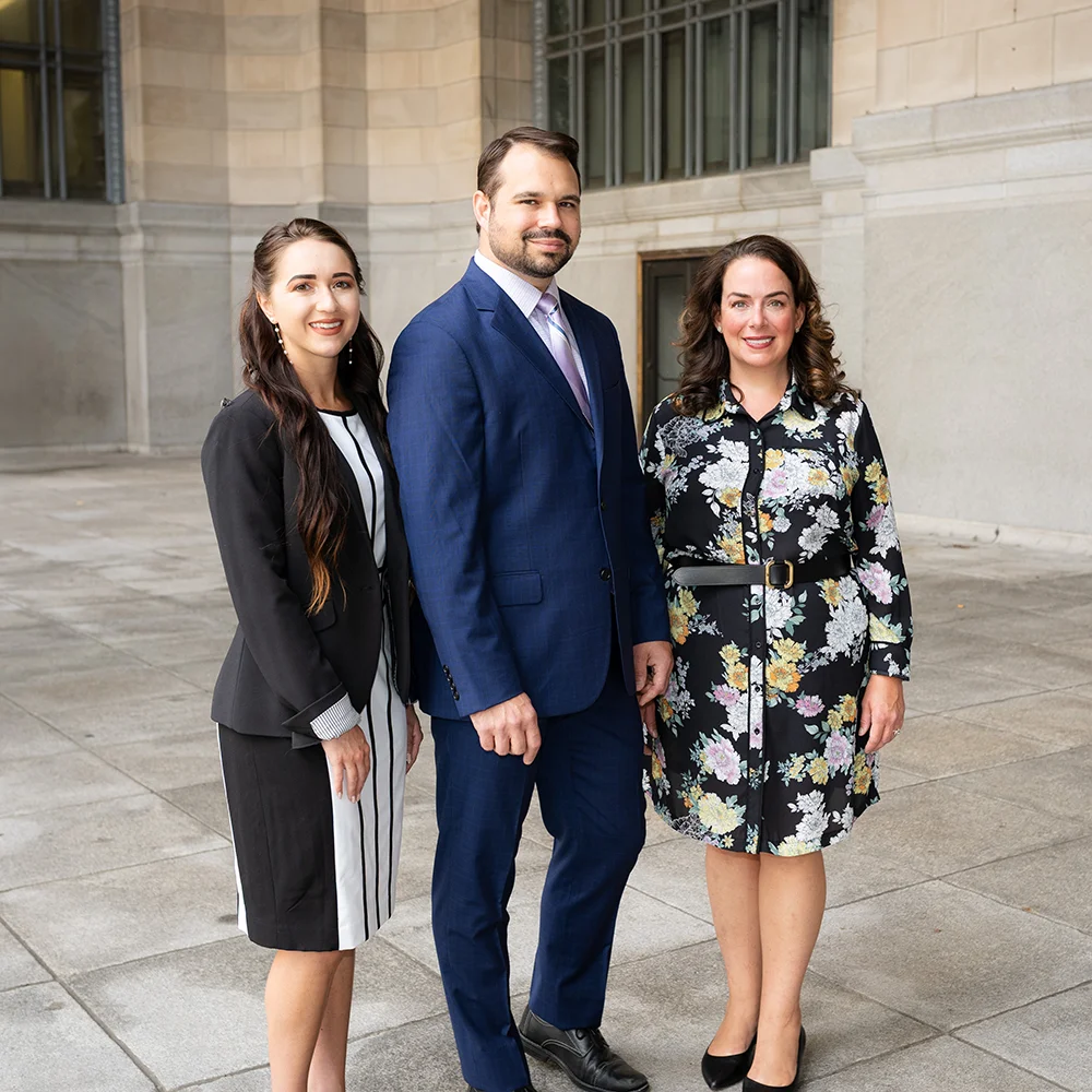 Lydia Kinnee, Joseph Froetschel and Laura D. Phillips of Phillips Froetschel standing outside a stone building