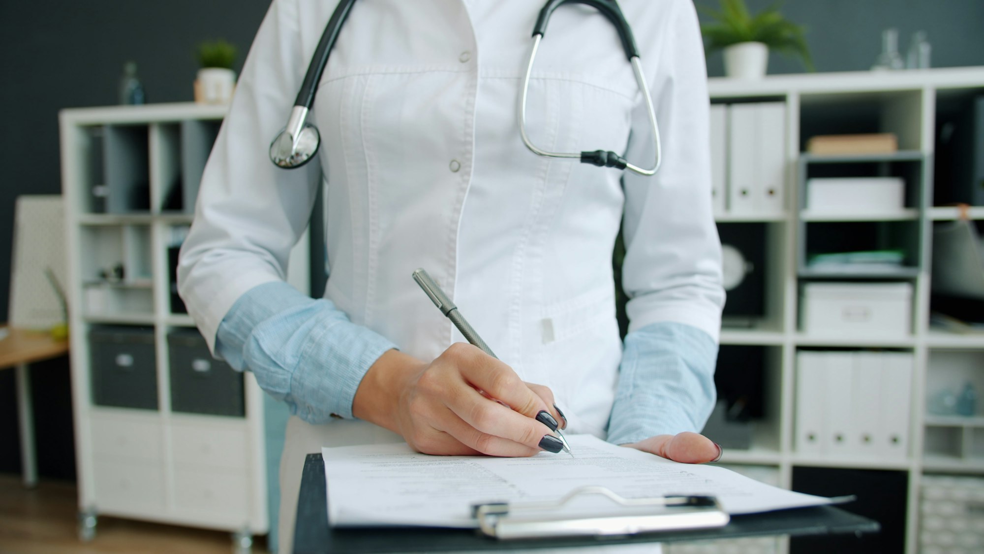 Physician writing notes in a patient's medical record
