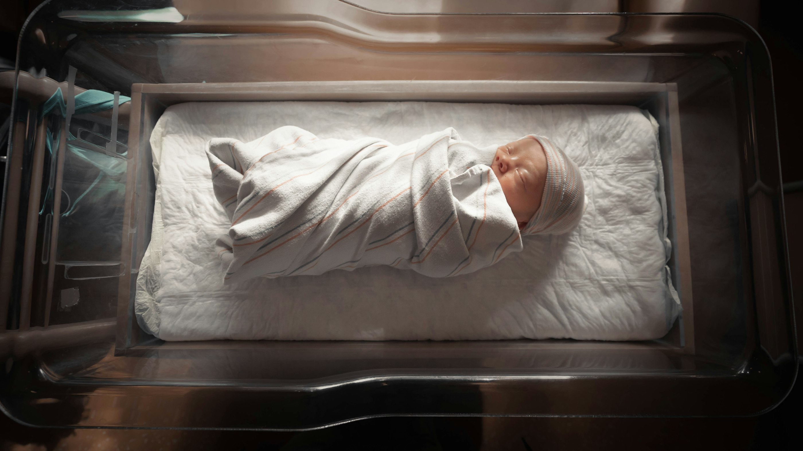 A parent holding a newborn in a hospital maternity room