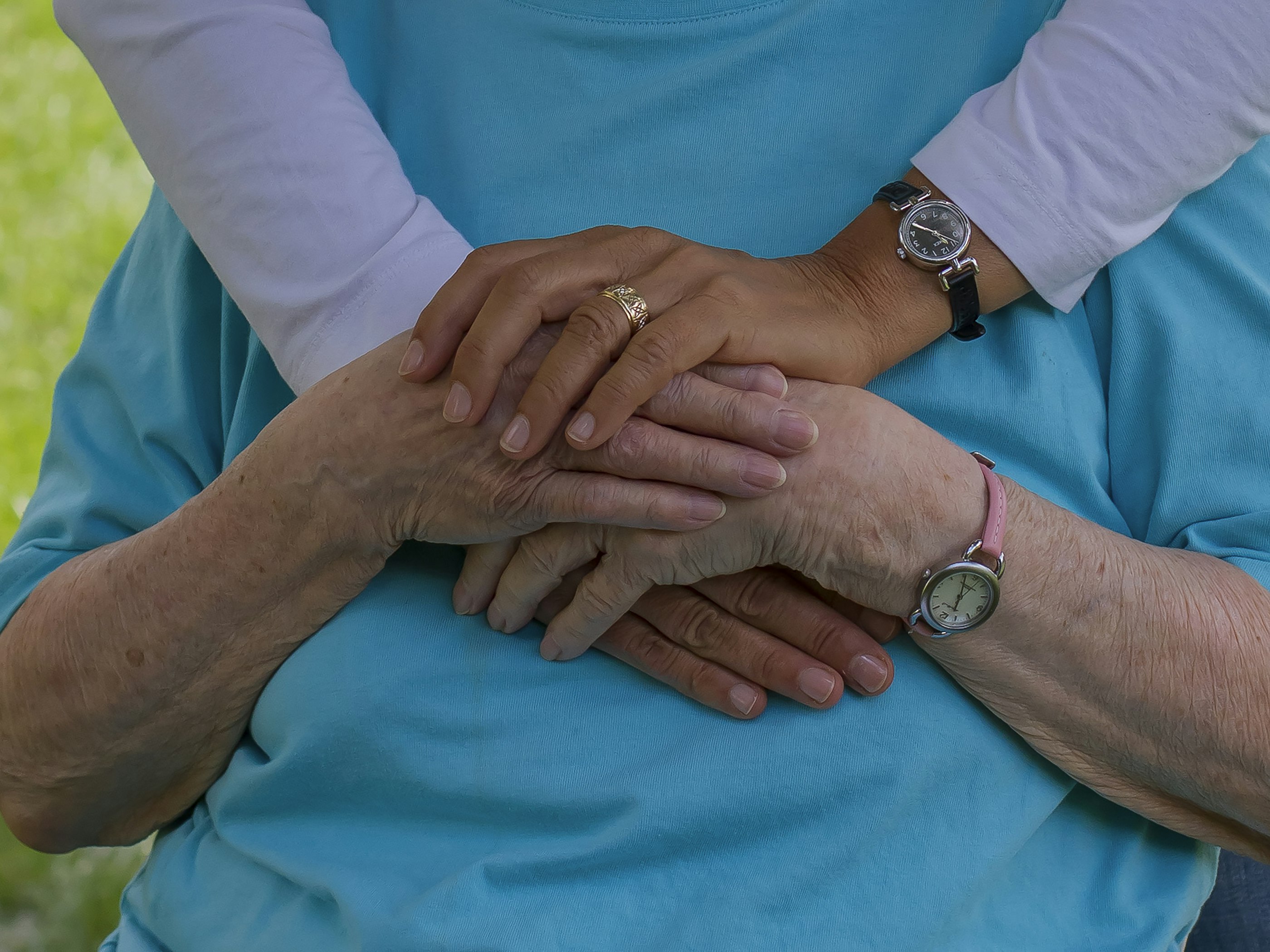 A caregiver holding an older person's hands