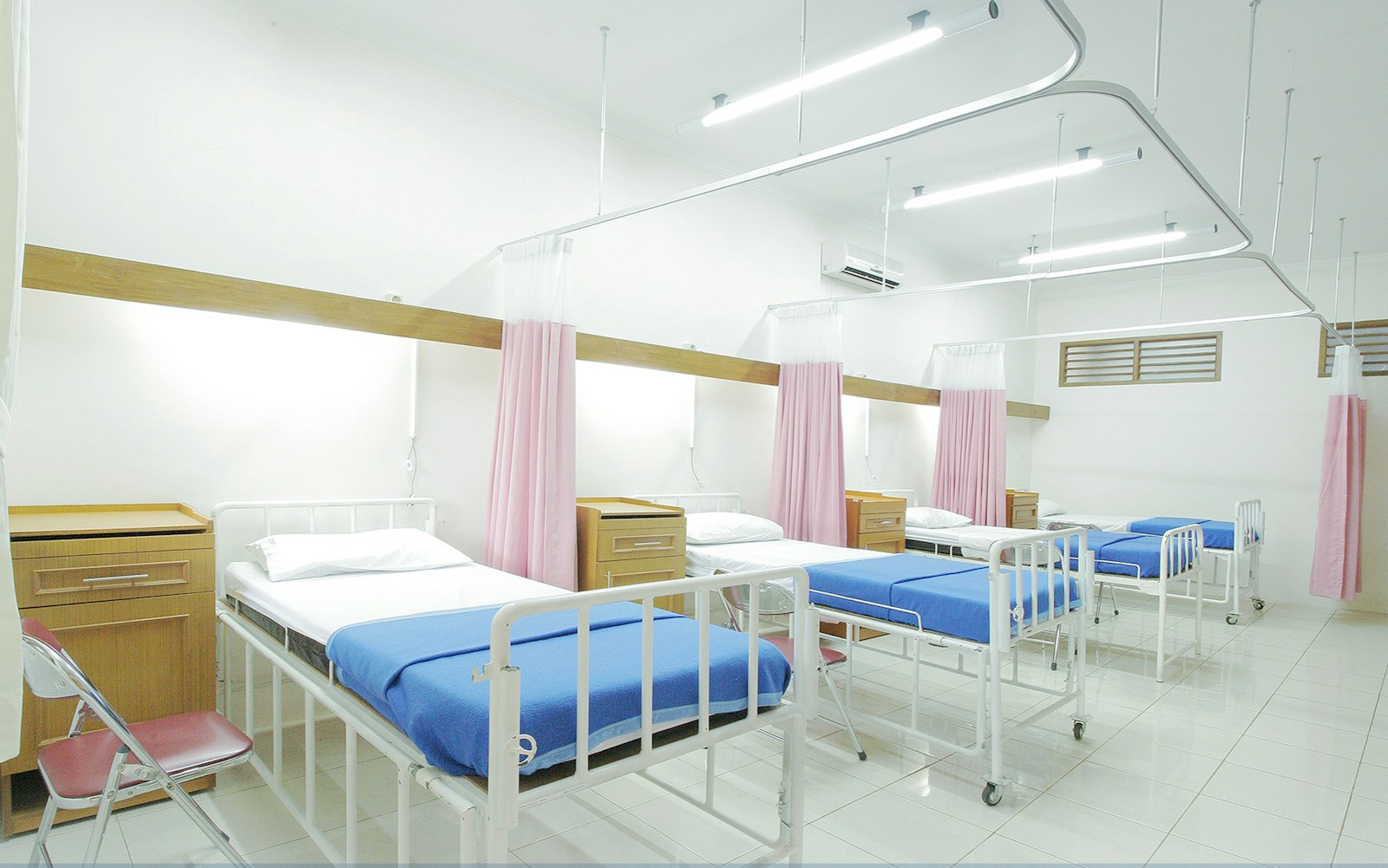 An empty hospital bed in a patient room