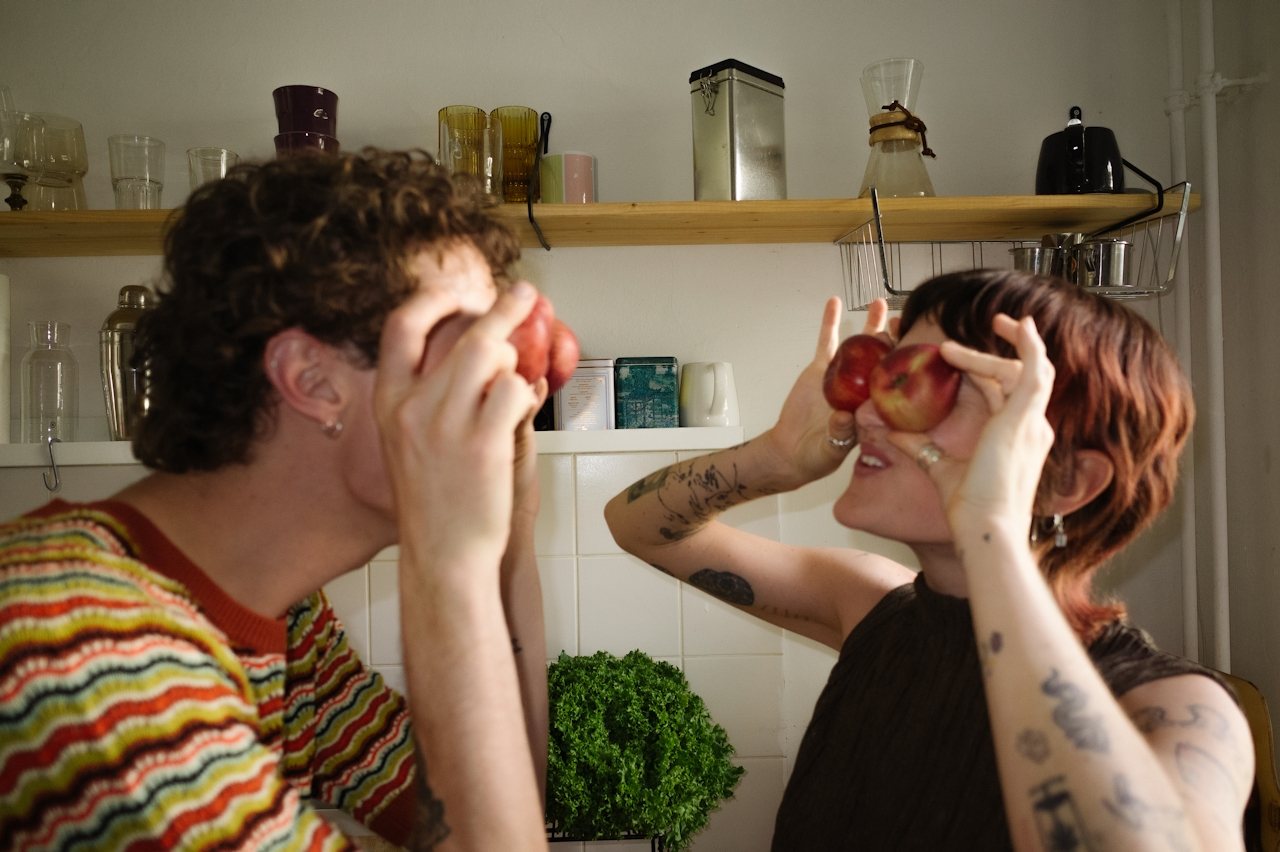 Two people laughing in a kitchen