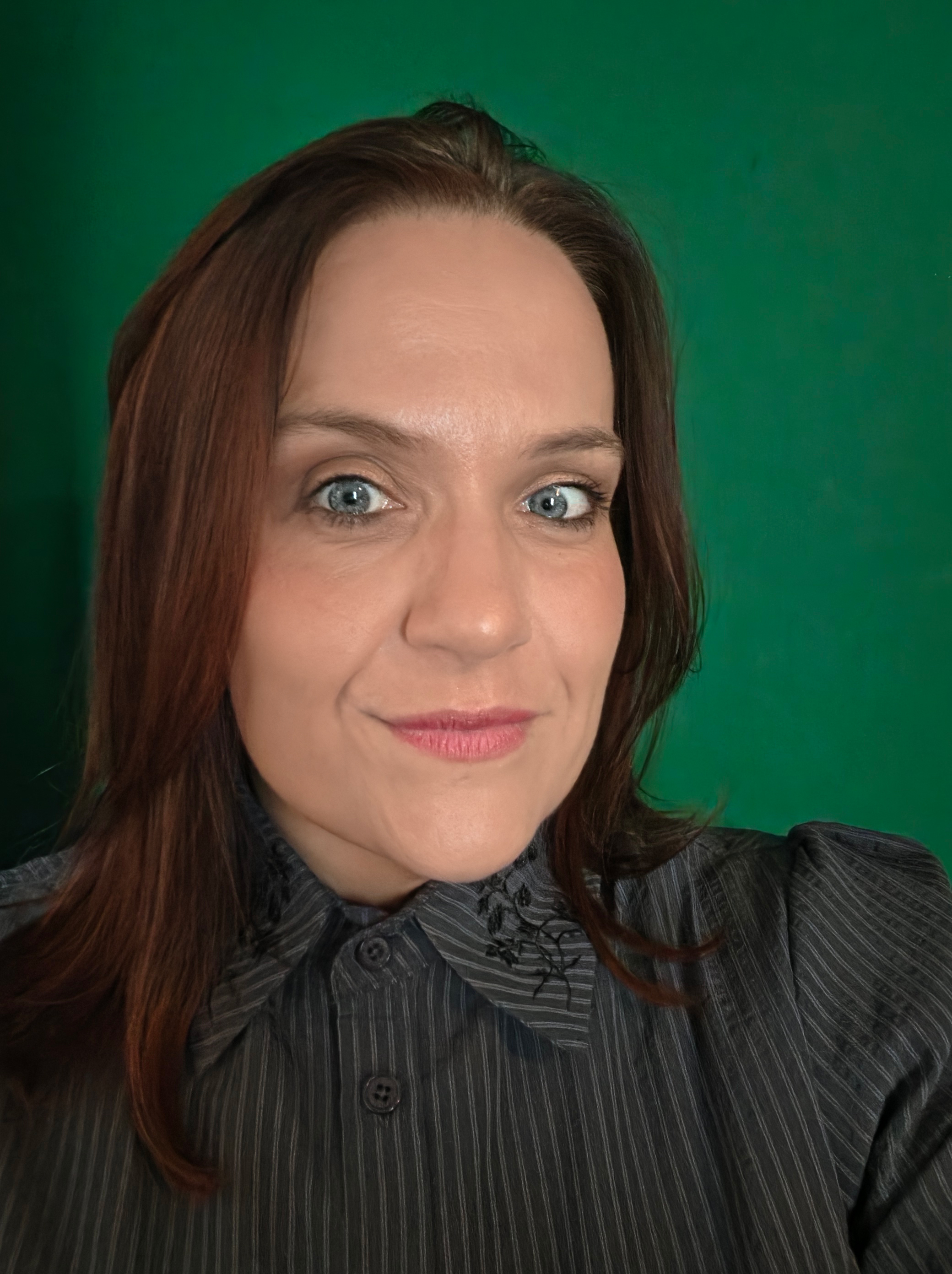 An image of a woman in a black top against a green background