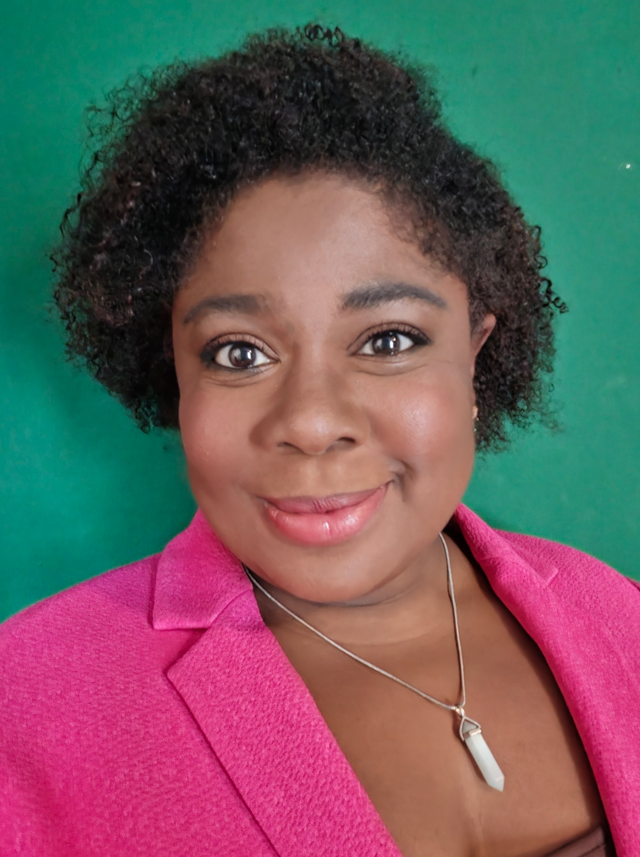 An image of a woman with a pink blazer against a green backgroud