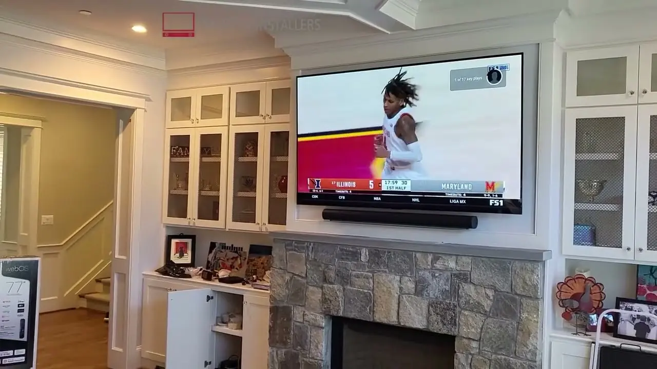 77-inch LG TV and soundbar installed above a stone fireplace