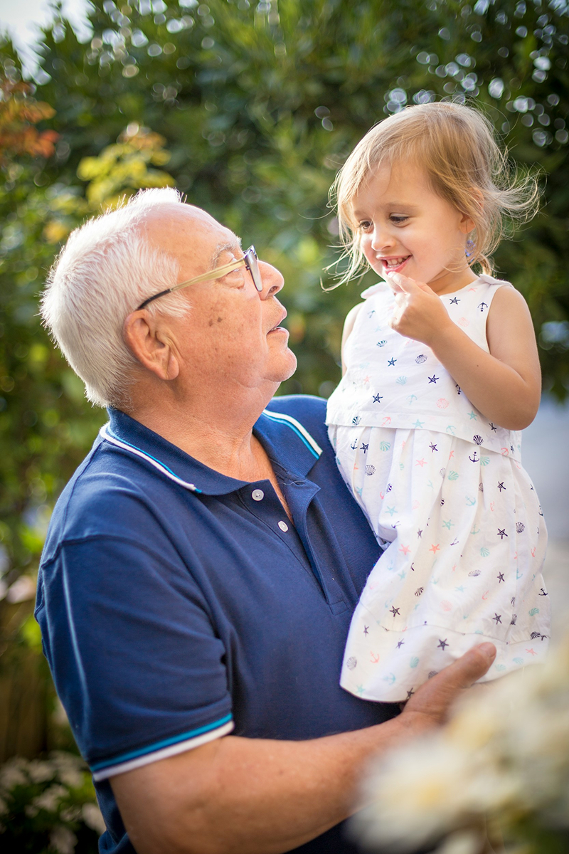 A grandfather holding his granddaughter