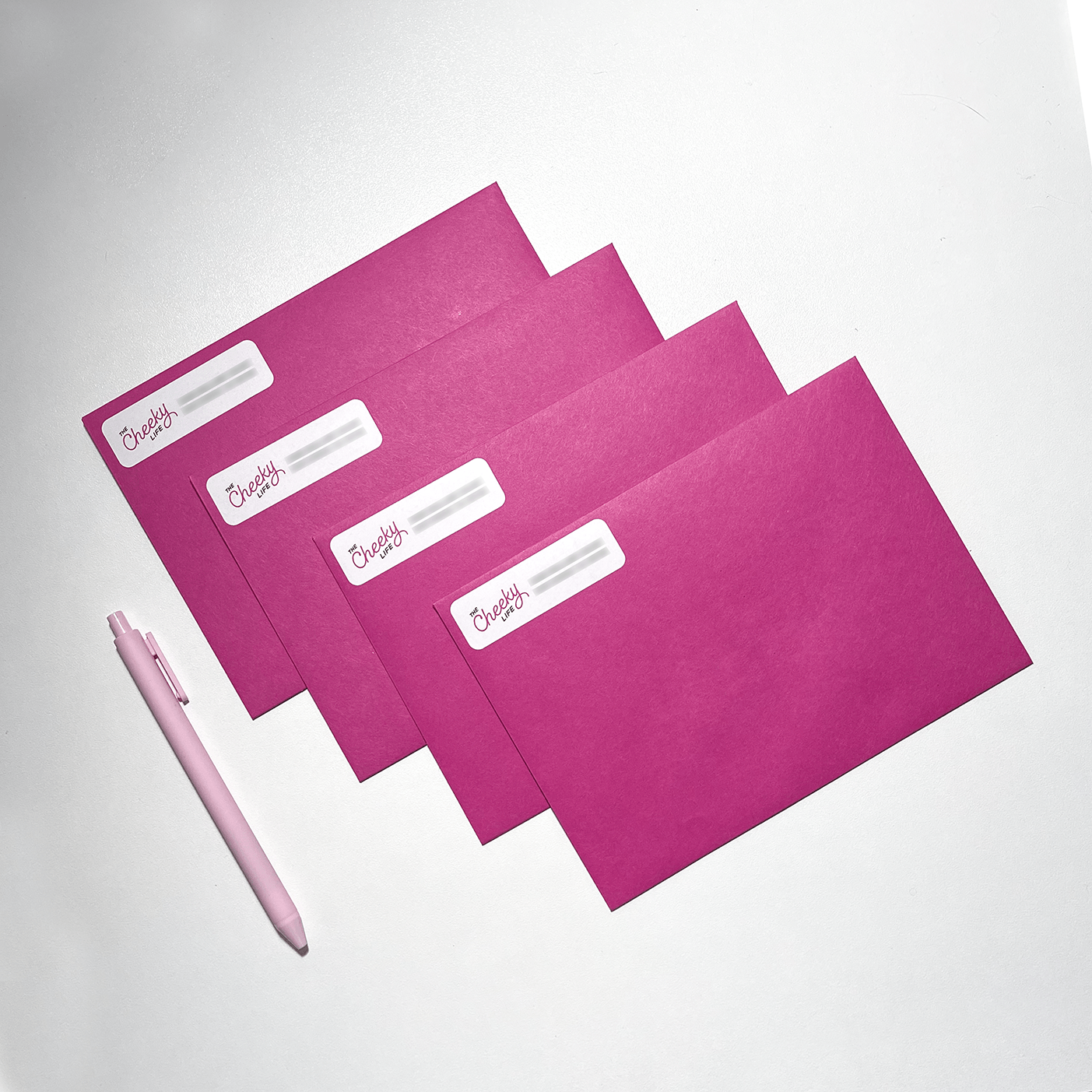 image of four pink envelopes on a white surface