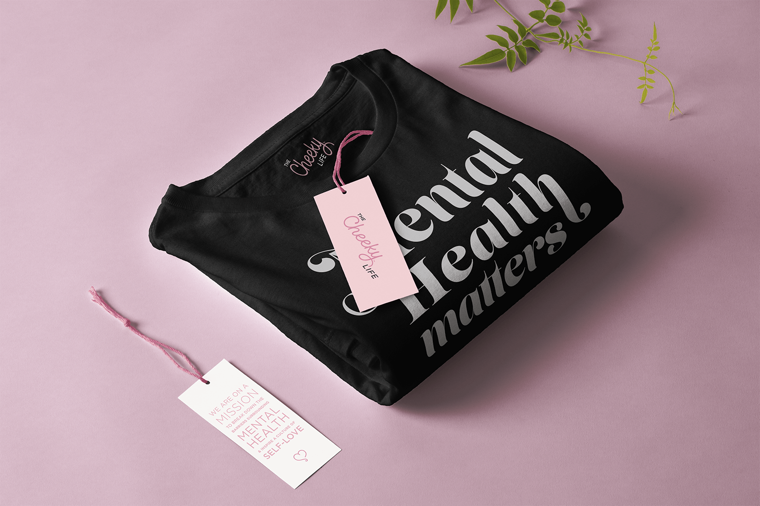 image of a black sweatshirt folded on a pink surface