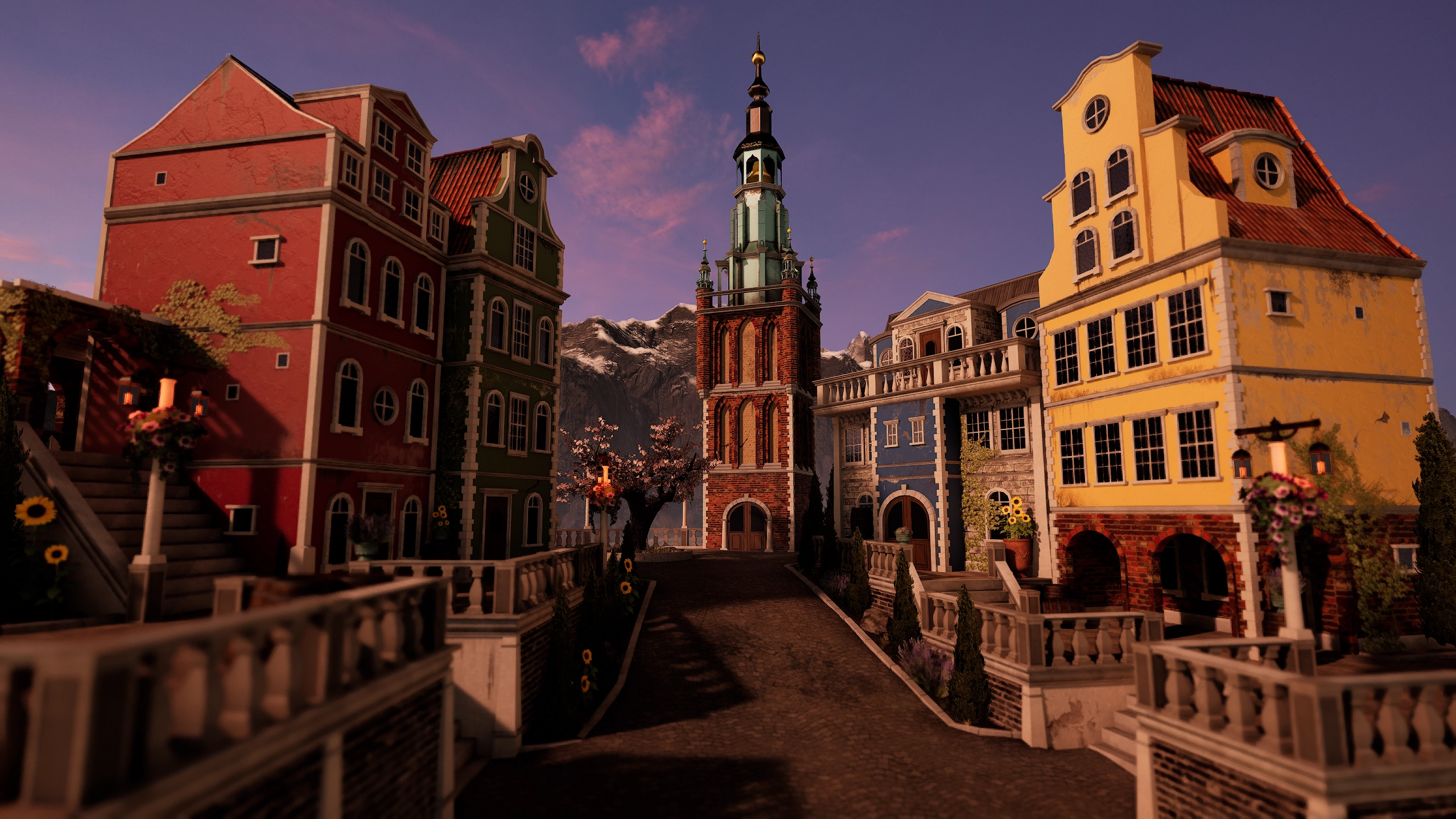 Cobbled street in a quaint European village with colorful houses in red, green, blue, and yellow, flanked by stone balustrades and lanterns, centered by a tall brick clock tower with a spire, set against a backdrop of snow-capped mountains at dusk.