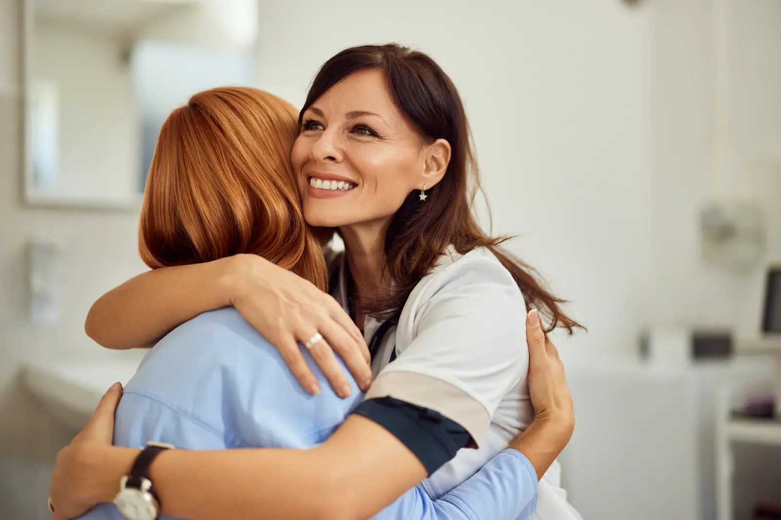 female dentist hugging female patient