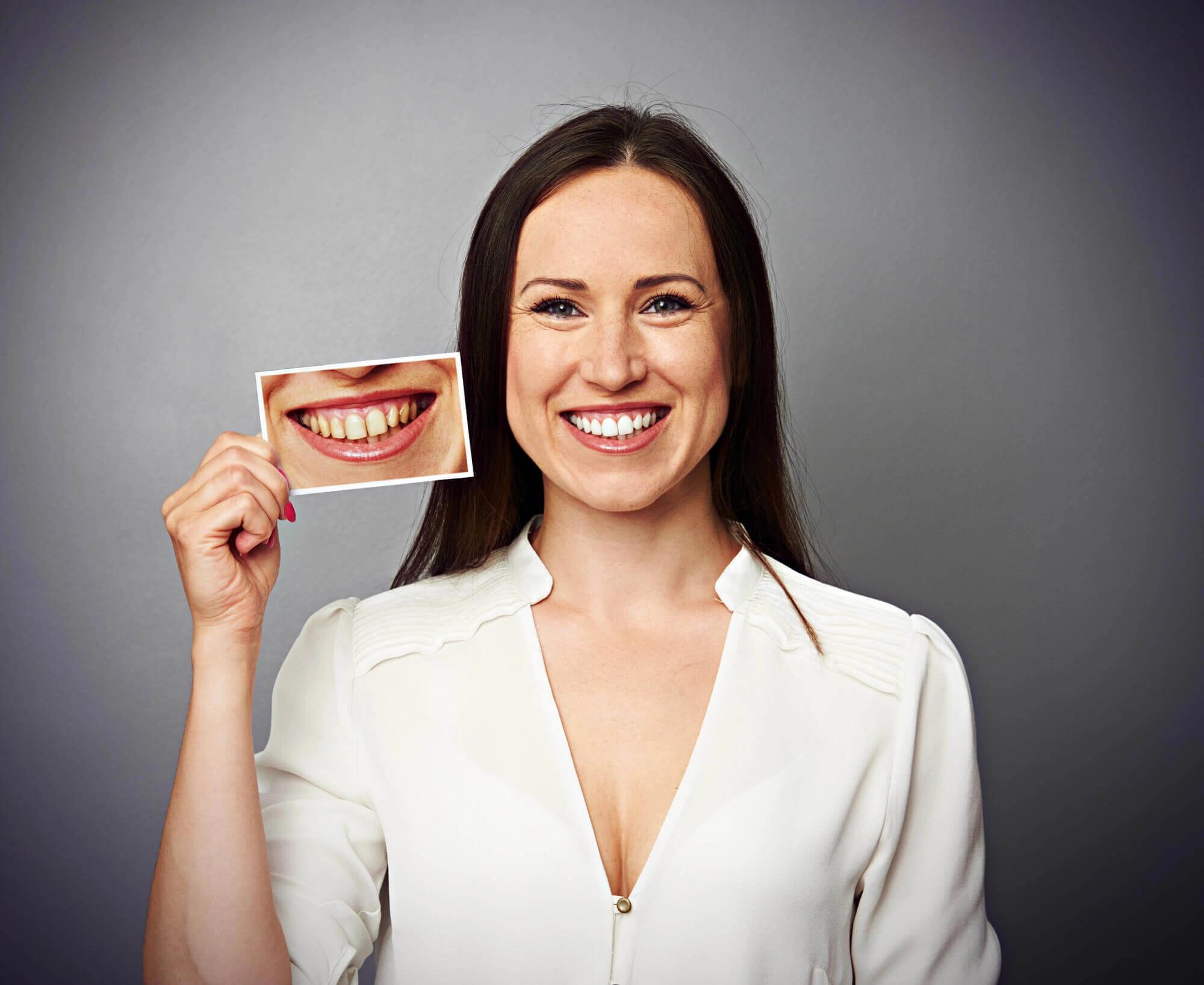 woman smiling and holding a picture of a smile