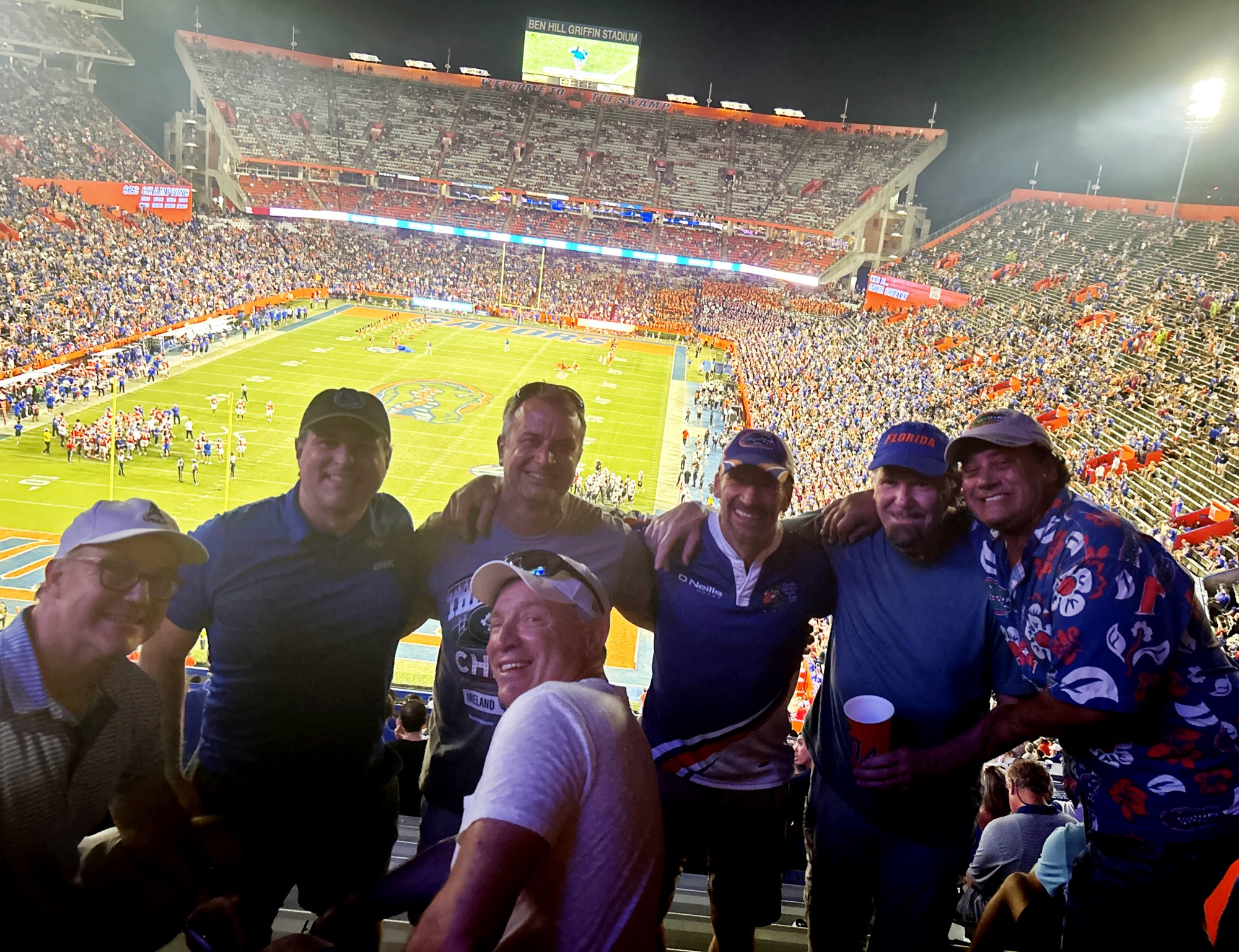Gator rugby alumni together in the stands at The Swamp under the lights