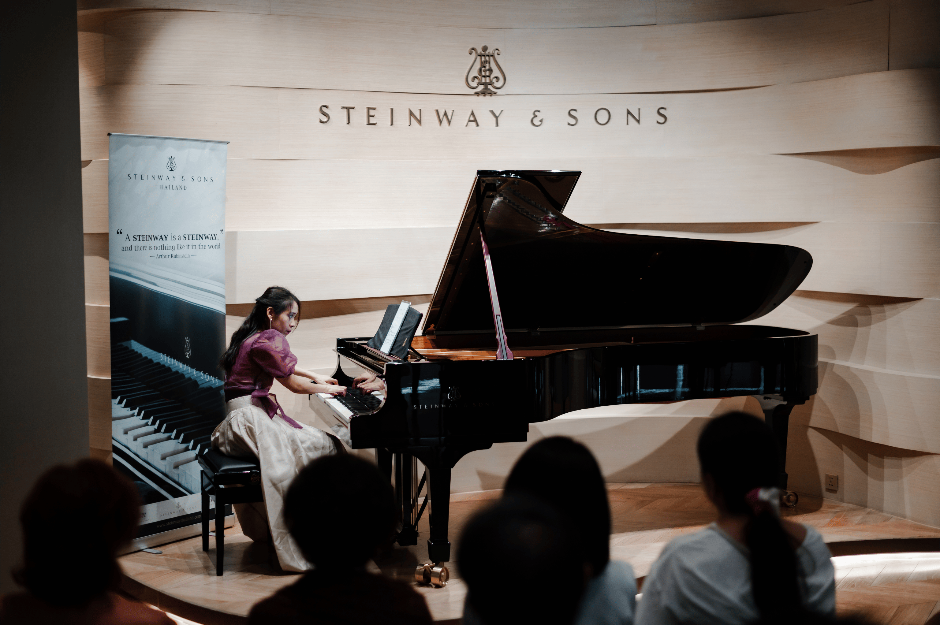 Dr. Helena Aung performing on a Steinway & Sons grand piano in a concert hall