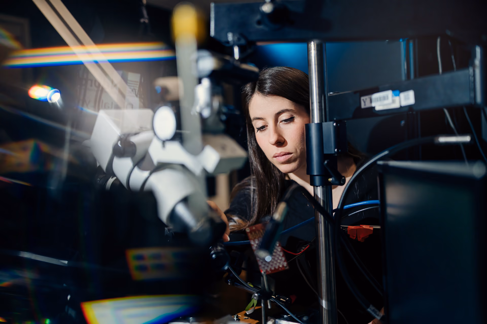 A lab member seated in front of a piece of lab equipment.