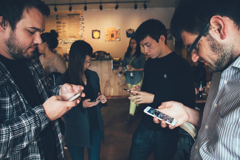 A group of people all looking at their phones