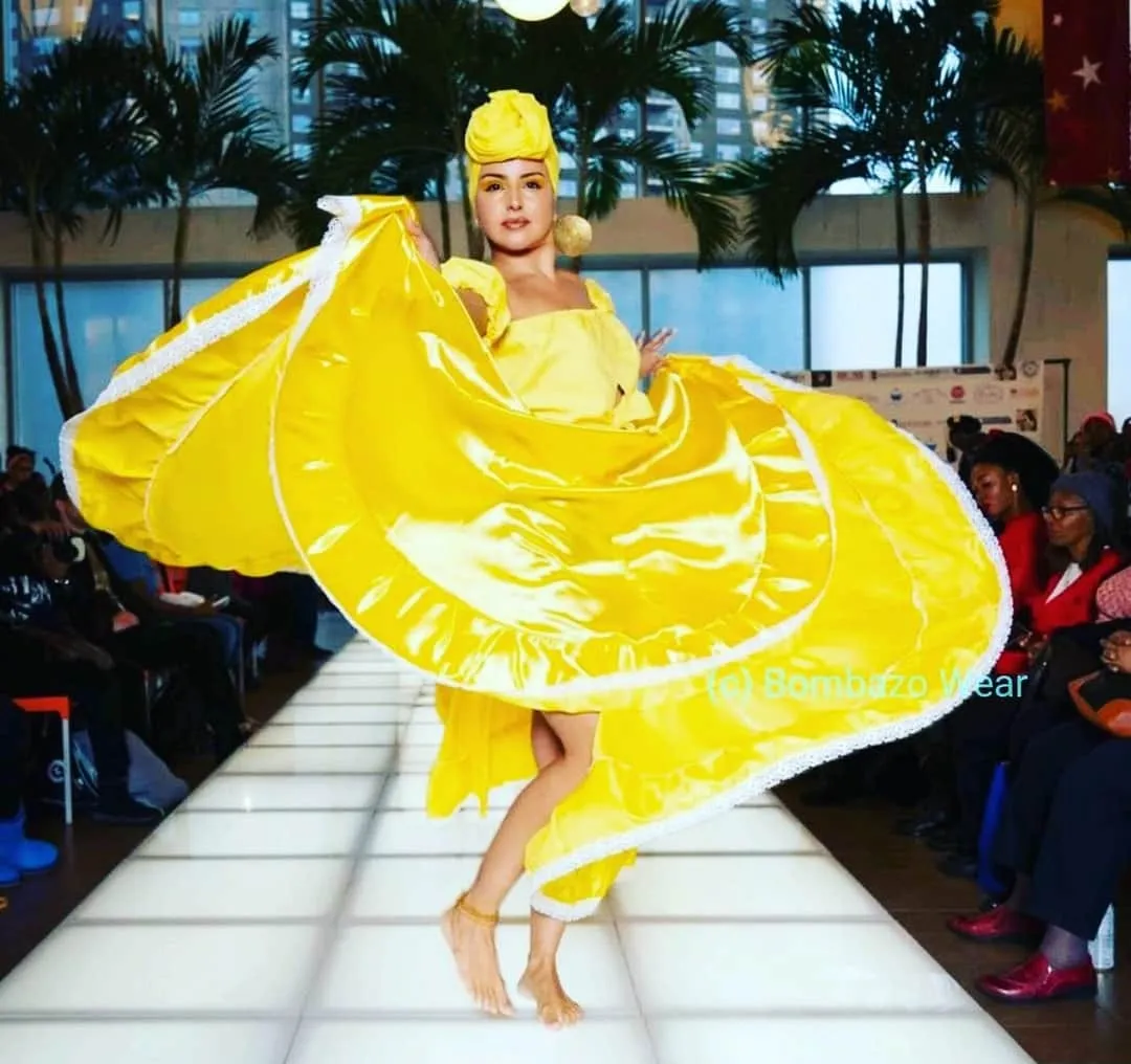 Cynthia Paniagua dancing bomba in a yellow dress on a Bronx runway