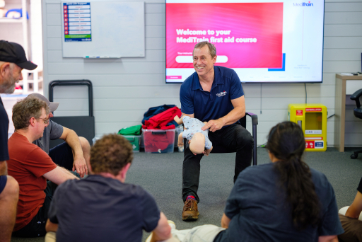 First aid trainee practising CPR on a manikin