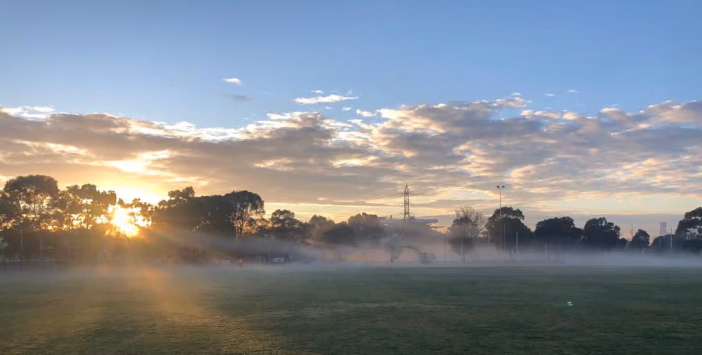 Sunrise over mist on an open field