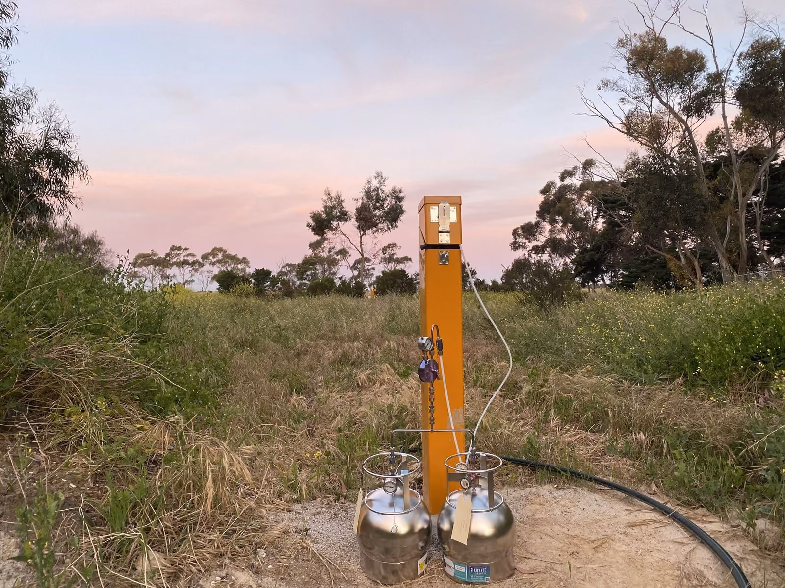 Landfill gas monitoring point with sampling canisters at dusk