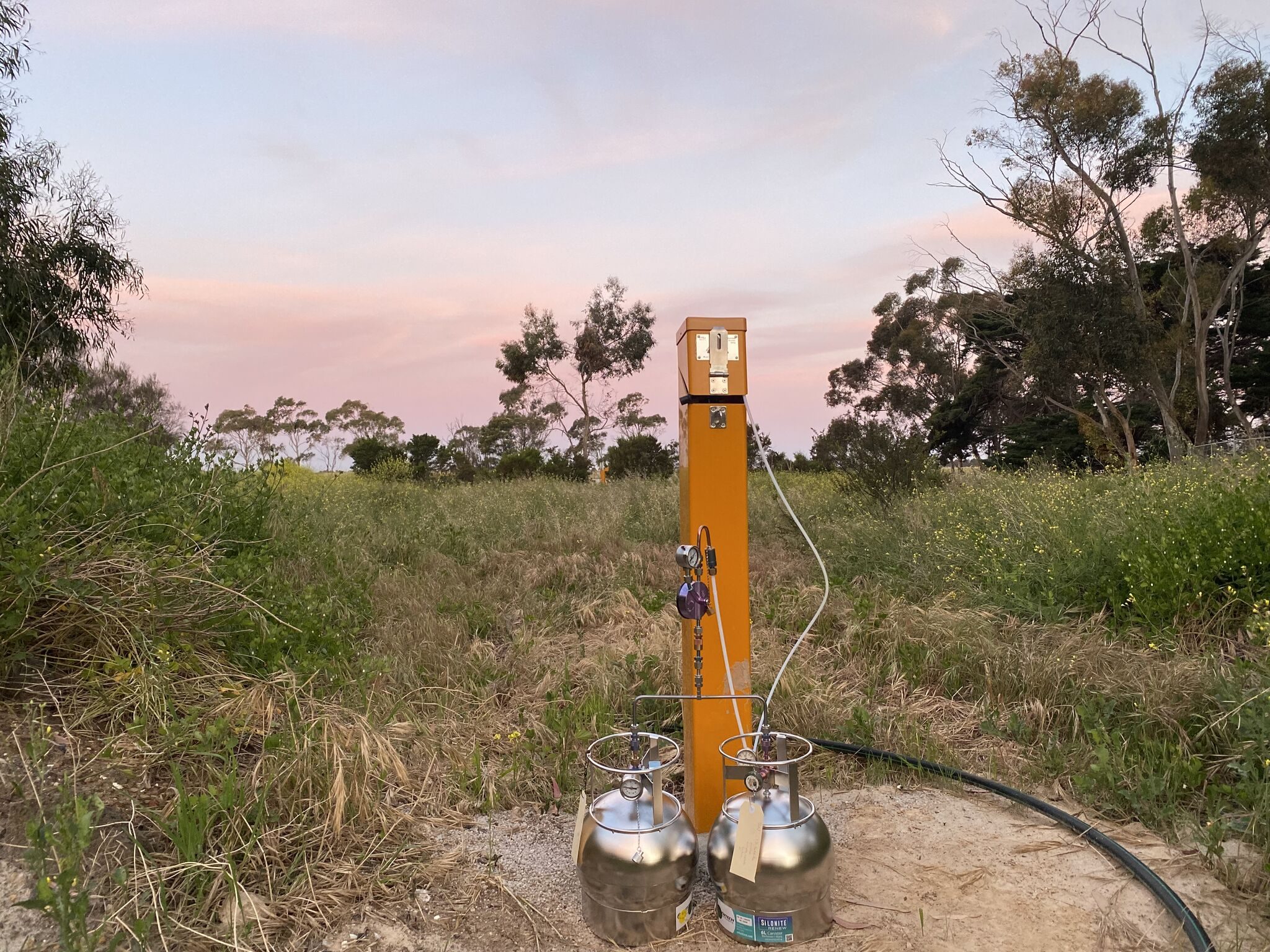 Landfill gas monitoring point with sampling canisters at dusk