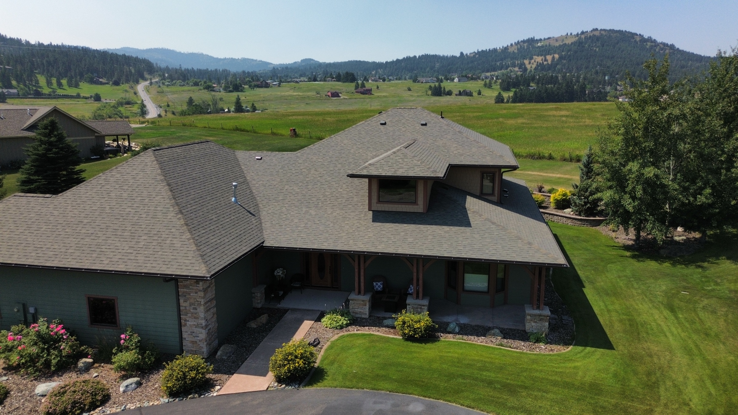 Aerial view of a shingle roof on a home surrounded by green lawn in Kalispell, Montana by Grizzly Ridge Roofing