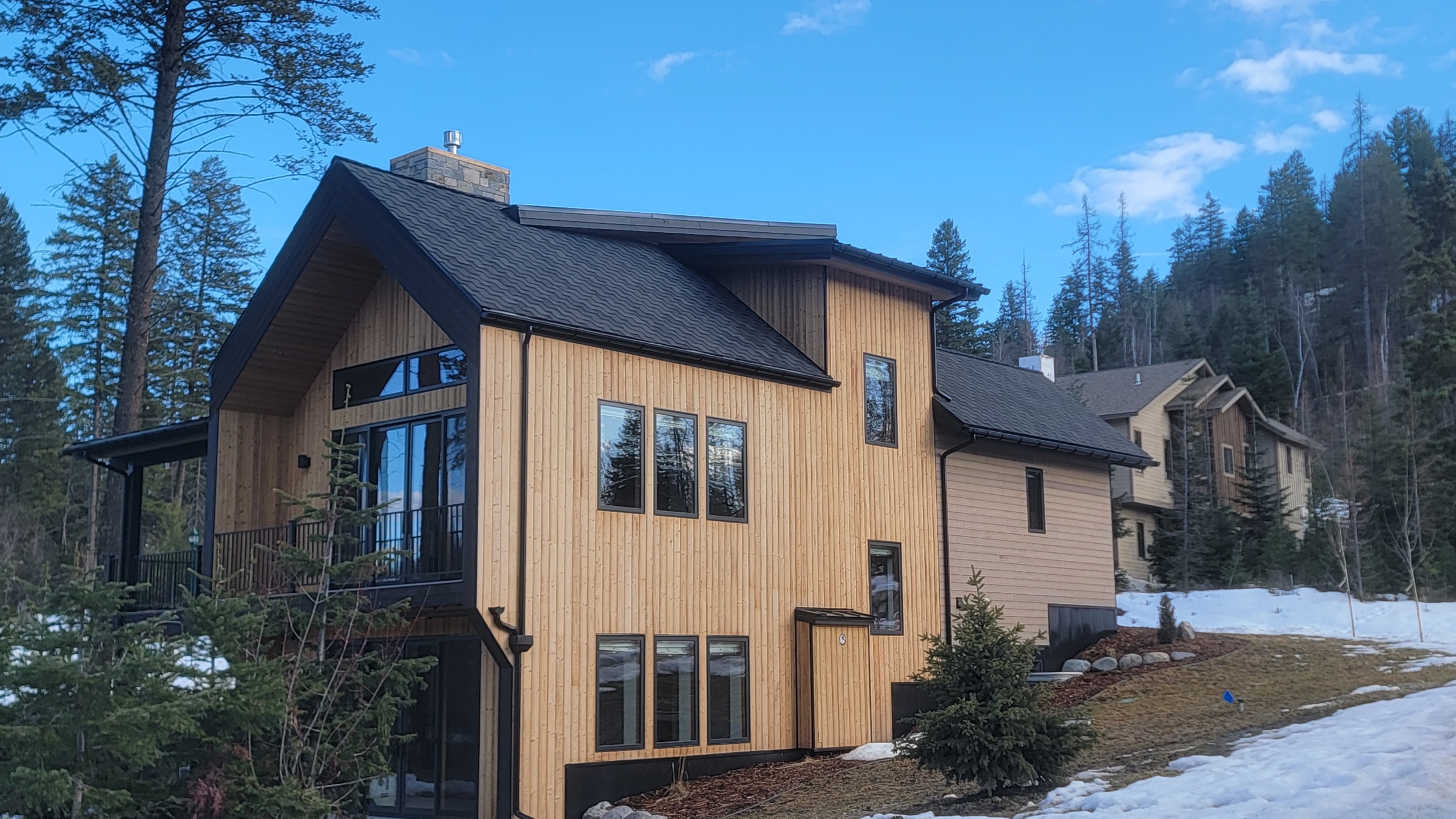 Mountain home with a designer shingle and standing-seam metal roof in Whitefish, Montana by Grizzly Ridge Roofing & Exteriors