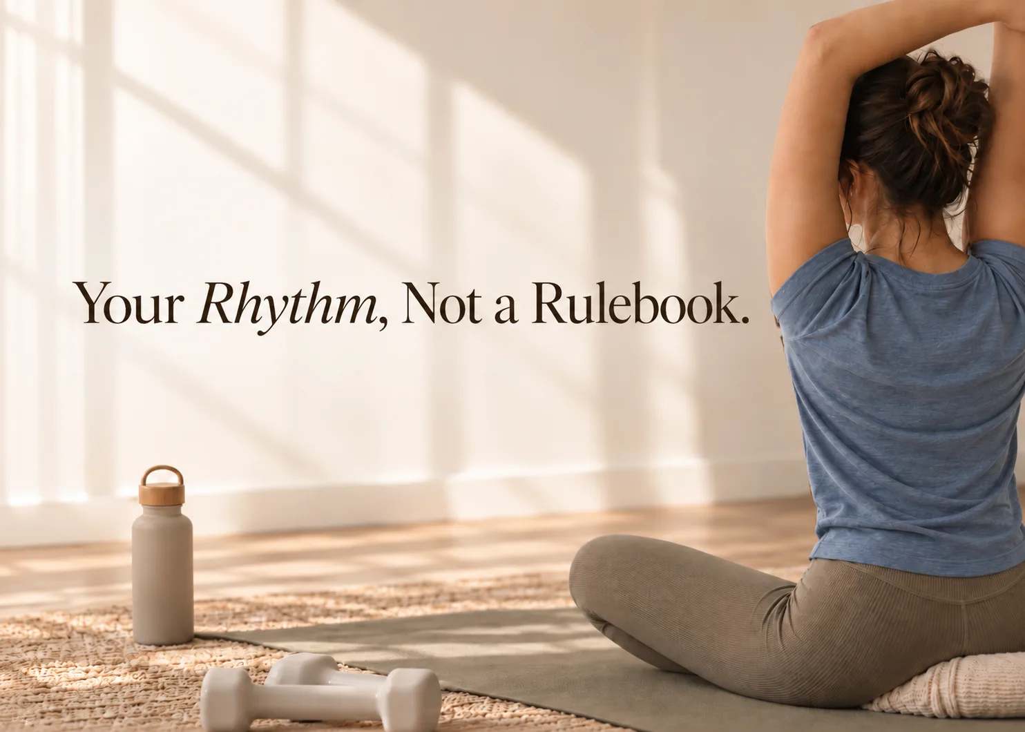 A woman stretching on a yoga mat in a sunlit room beside the line: your rhythm, not a rulebook