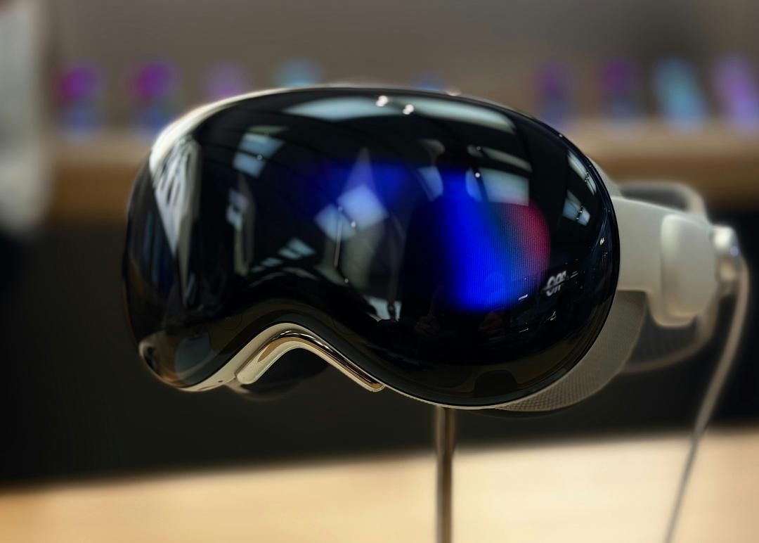 Apple Vision Pro mixed reality headset powered on and shown on display, with its curved glass front and light seal